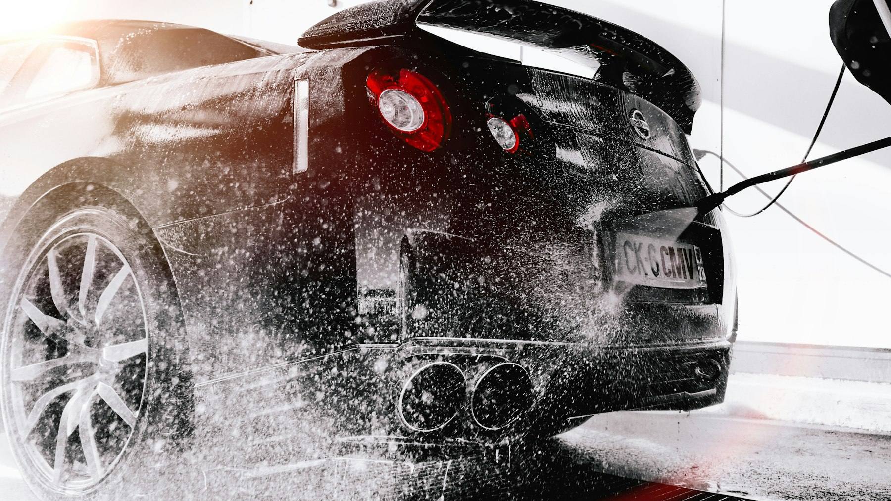 Black sports car covered in thick snow foam