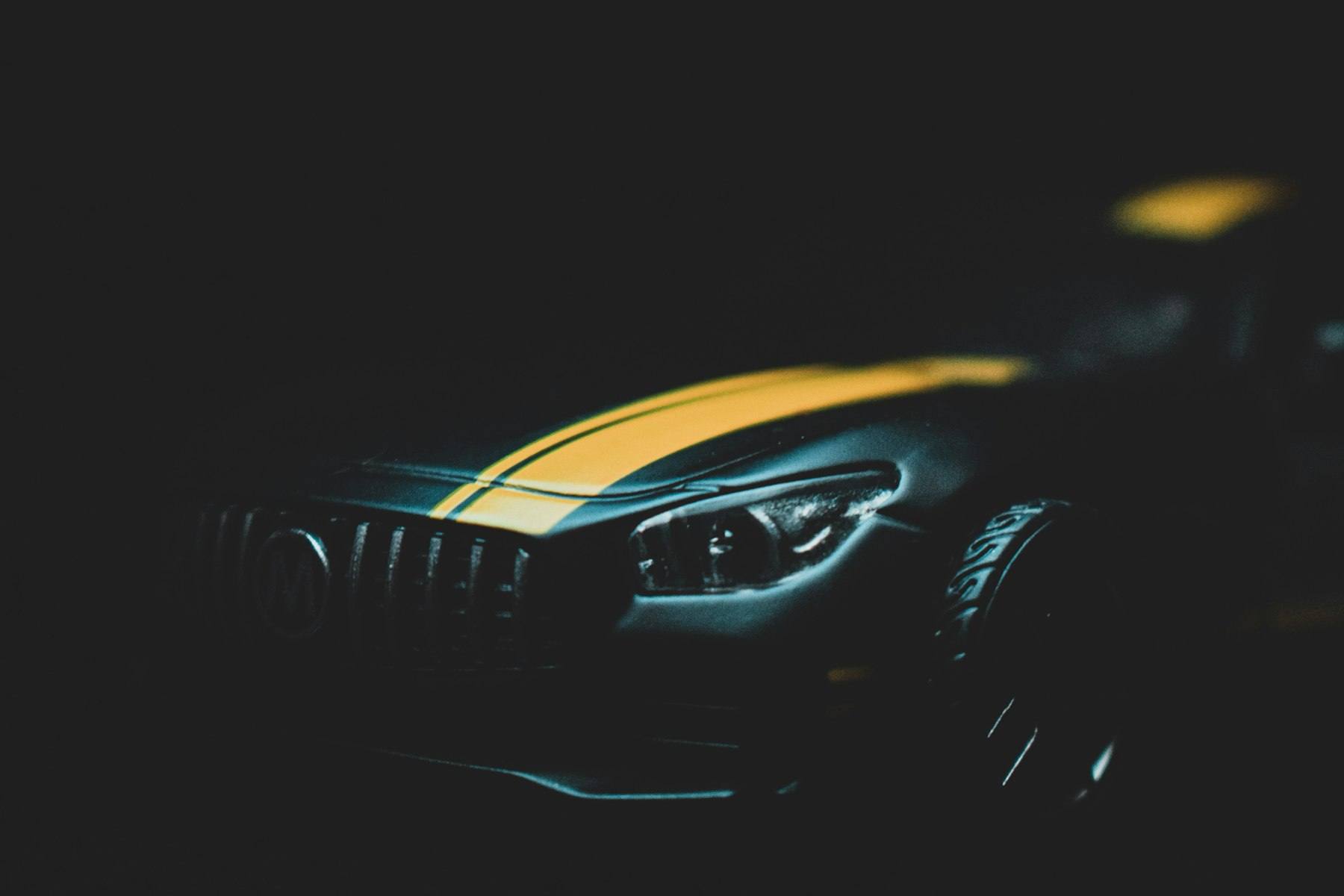 Yellow and black car in a dark studio